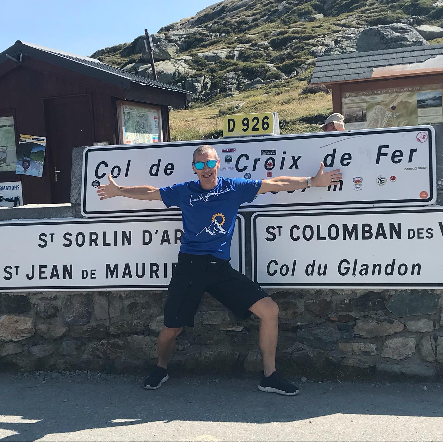 Cycle guide in front of the sign of a French mountain col