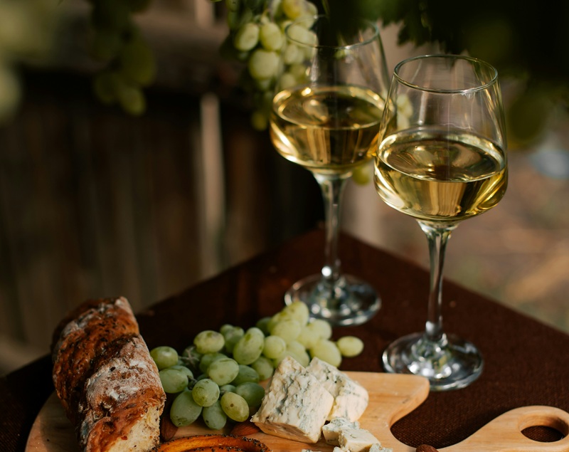 cheeseboard and baguette with white wine and grapes